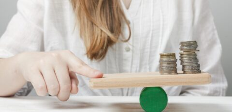 woman-holding-her-finger-balance-with-coins