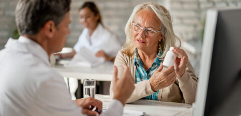 Senior woman talking with her doctor about her prescription medicines during consultations at clinic.